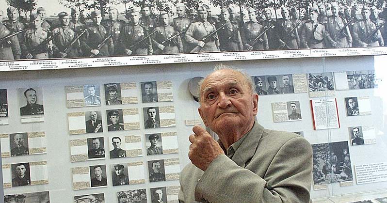 Александр Дитлов на фоне своих военных фотографий